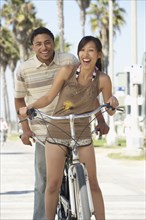 Young couple standing with tandem bicycle