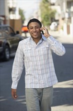 Young mixed race man in street using cell phone