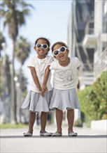 Young mixed race girls wearing sunglasses