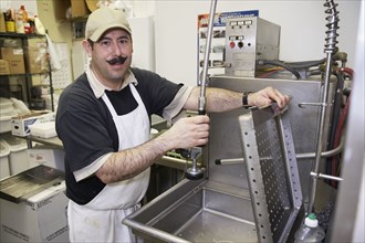 Hispanic dishwasher in commercial kitchen