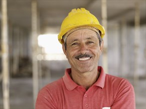 Hispanic worker smiling on construction site