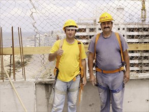 Hispanic workers smiling on construction site