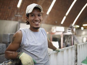 Hispanic worker smiling in factory