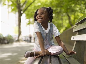 African girl smiling on bench