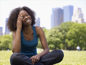 African woman laughing in park