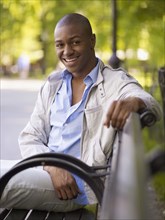African man smiling on bench