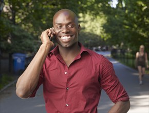 Smiling African man using cell phone
