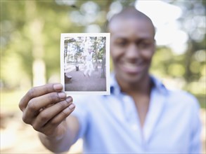 African man holding photograph