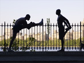 African men stretching on railing