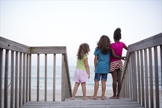 Girls standing together on deck near ocean