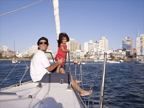 Hispanic father and daughter on sailboat