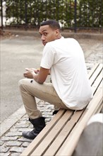 Haitian man sitting on bench