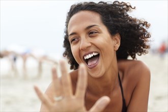 Laughing mixed race woman on beach