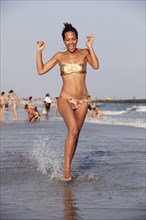 Mixed race woman wading in ocean on beach
