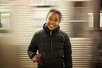 Mixed race girl smiling in subway station