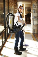 Hispanic woman vacuuming floor