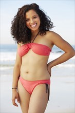 Mixed race woman smiling on beach