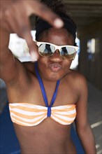 Black girl in bikini gesturing outdoors