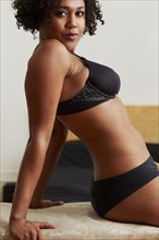 Mixed race woman wearing black bra and panties