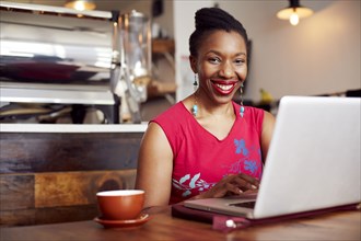 Woman using laptop in cafe