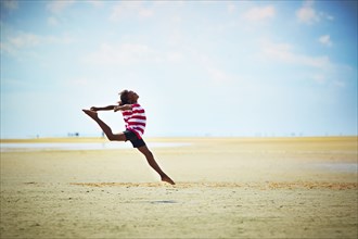 Black girl jumping for joy on beach