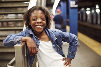 Smiling girl leaning on subway staircase