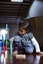 Close up of mixed race girl stacking wooden blocks
