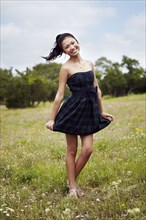 Mixed race teenage girl smiling in field