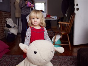 Girl playing with plush toy in living room
