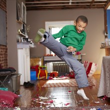 Black boy doing karate kick in living room