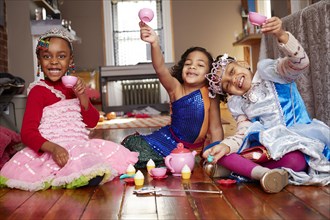 Girls playing dress-up and posing at tea party