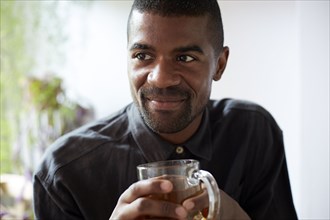 Black man drinking cup of tea