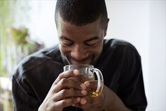 Black man drinking cup of tea