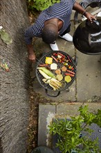 High angle view of African American man grilling at barbecue