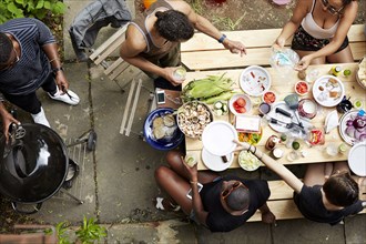 High angle view of friends eating at backyard barbecue