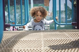 Mixed race boy climbing on play structure