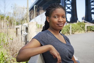 Smiling Black woman sitting on bench outdoors