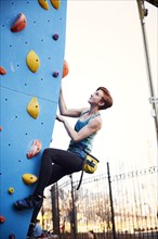 Caucasian woman climbing outdoor climbing wall