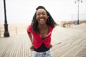 Black woman laughing on boardwalk