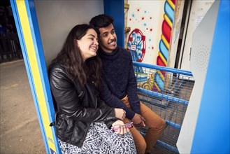 Couple posing in photo booth at amusement park