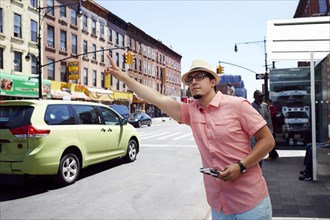 Hispanic man hailing taxi in city