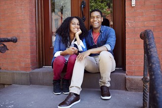 Smiling couple posing on front stoop