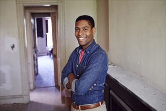 Smiling man posing in empty house