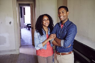Smiling couple posing in empty house