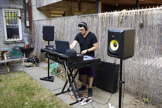 Hispanic dj playing music in backyard