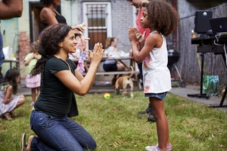Mixed Race mother and daughter playing clapping game