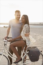 Couple with bicycle on beach