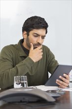 Indian businessman using digital tablet in office