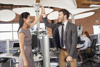 Business people high fiving in office