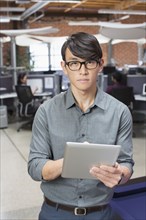 Businessman using digital tablet in office lounge area